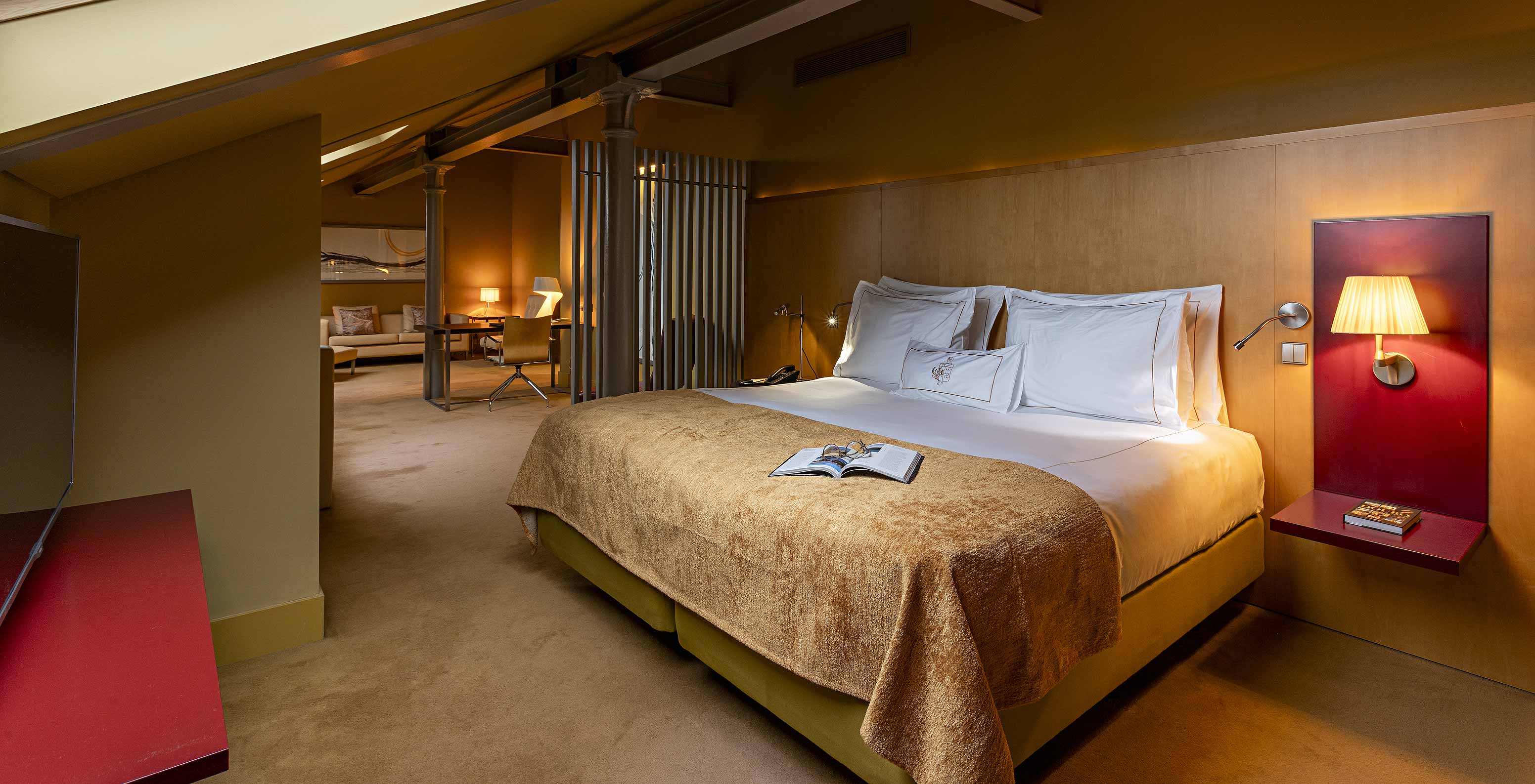 Pestana Palácio do Freixo’s Loft Attic is in the attic, with a double bed and yellow bedspread