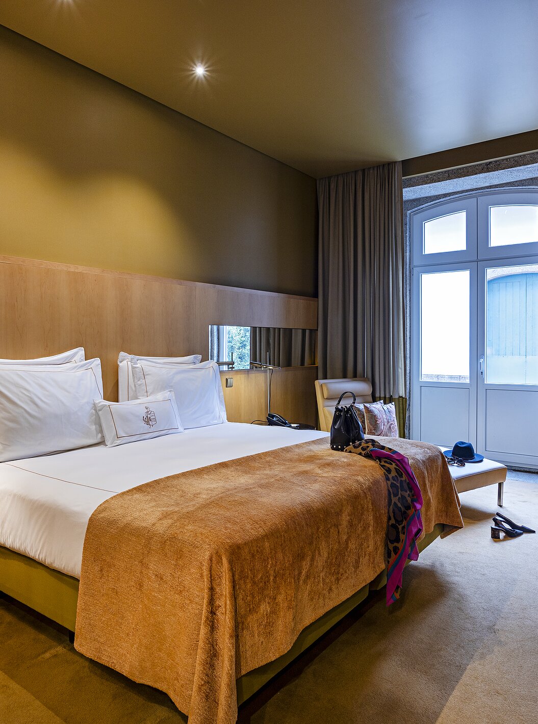 Pestana Palácio do Freixo’s Classic room has a large window, double bed, and a bedside table