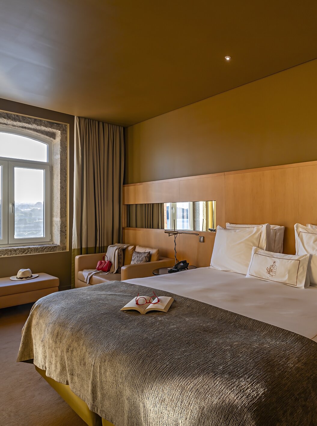 The Executive Superior has a double bed, a sofa, and a pouf by the window