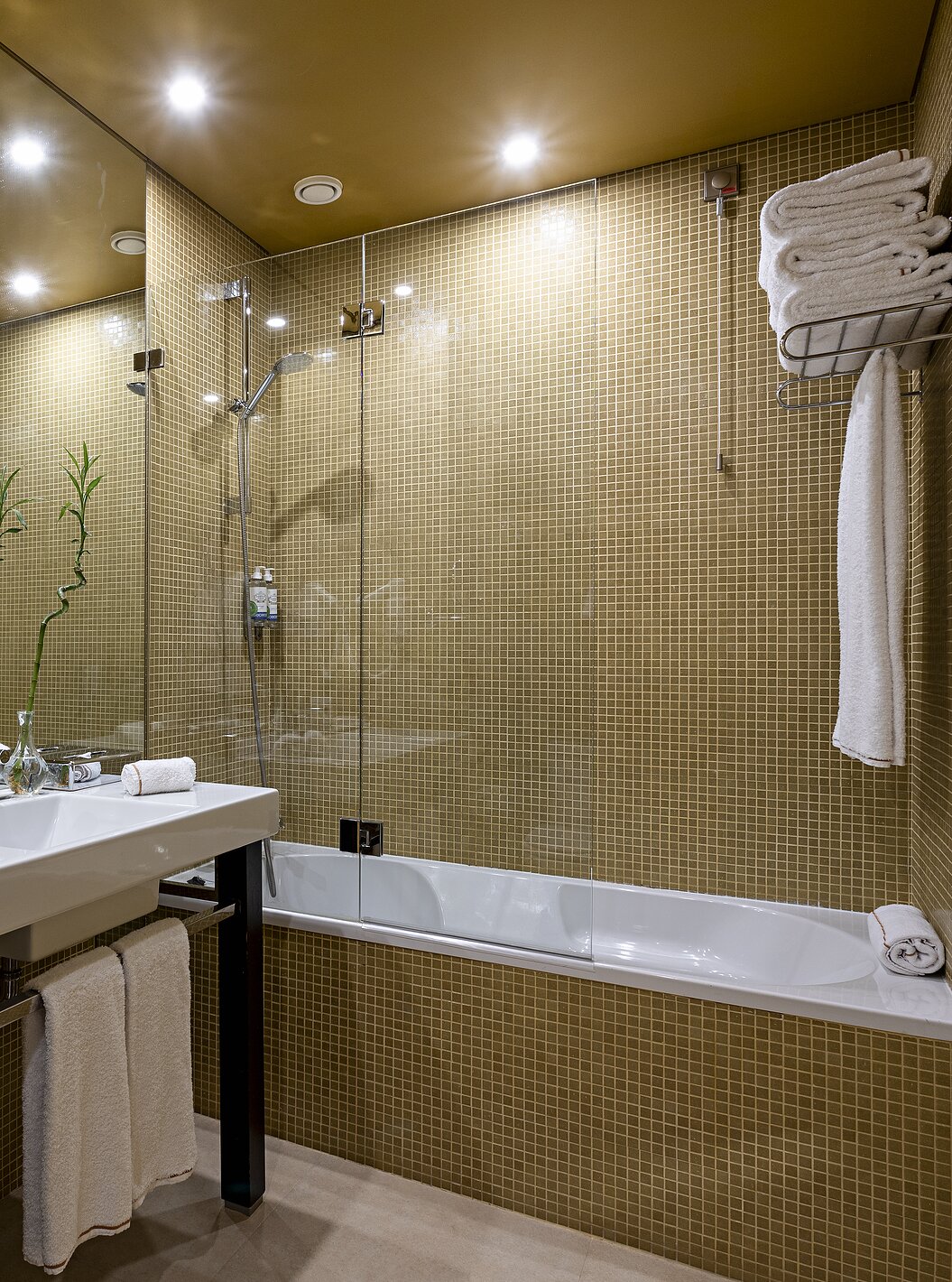 The Junior Suite has a bathroom with yellow tiles, a sink, and a bathtub