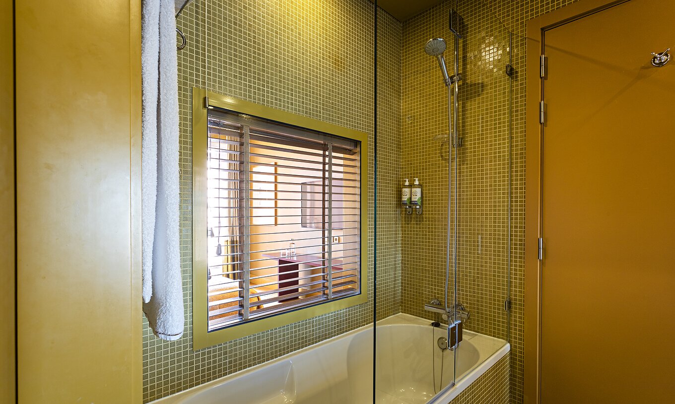 The Suite Balcony has a bathroom with a bathtub and a window to the bedroom