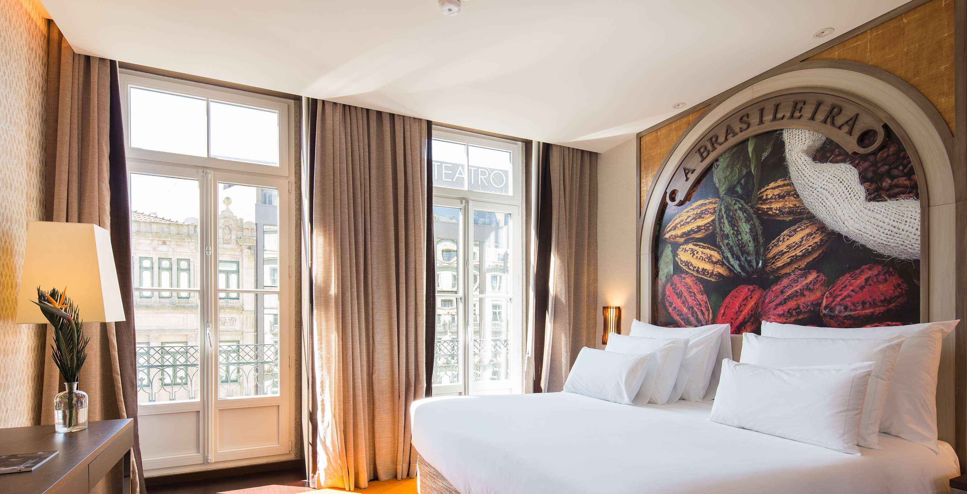 The Deluxe Superior do Pestana Porto - A Brasileira has two windows with a small balcony and a view of the city