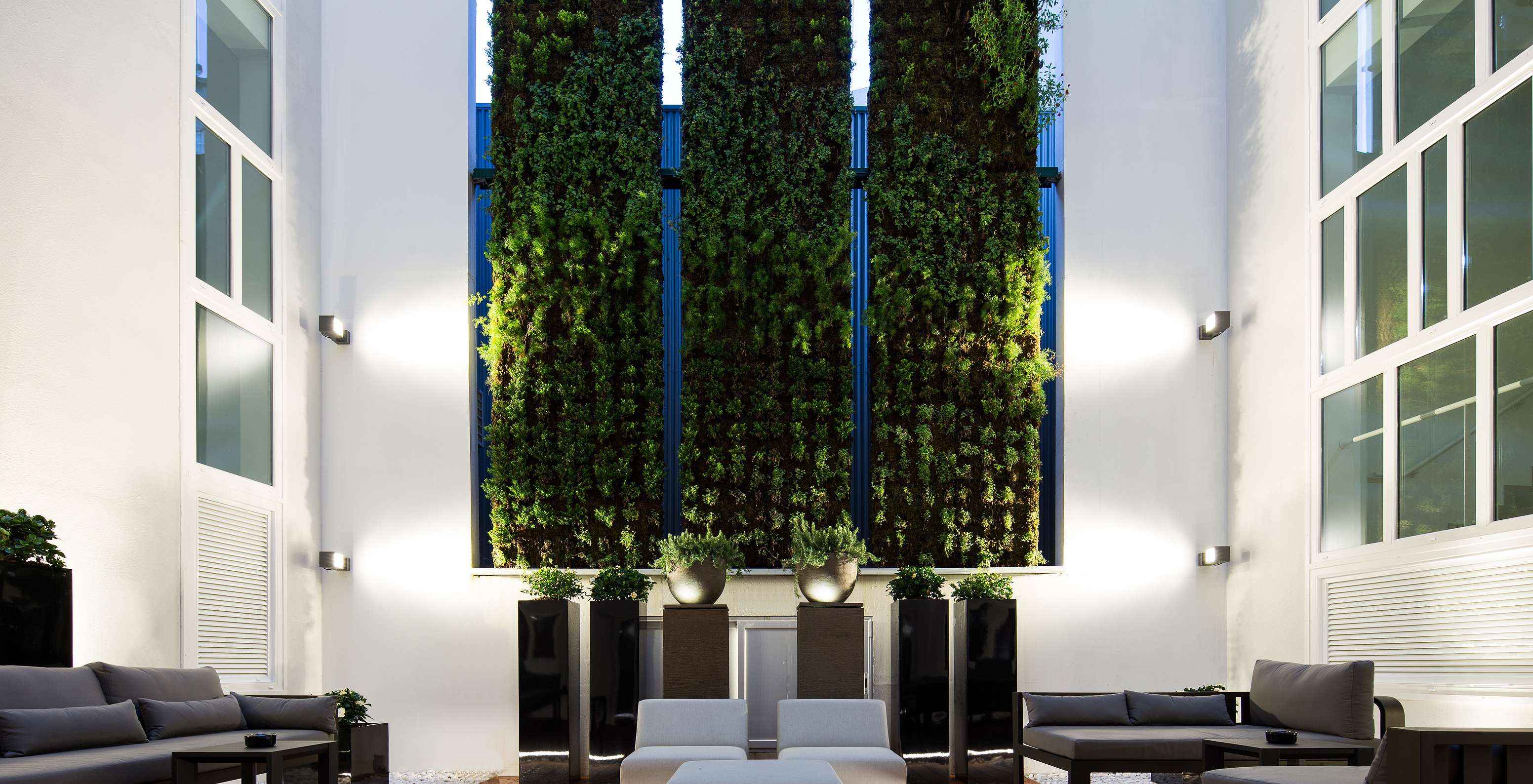 Pestana Porto - A Brasileira, a 5-star hotel in Porto, has a courtyard with a green wall of plants and sofas