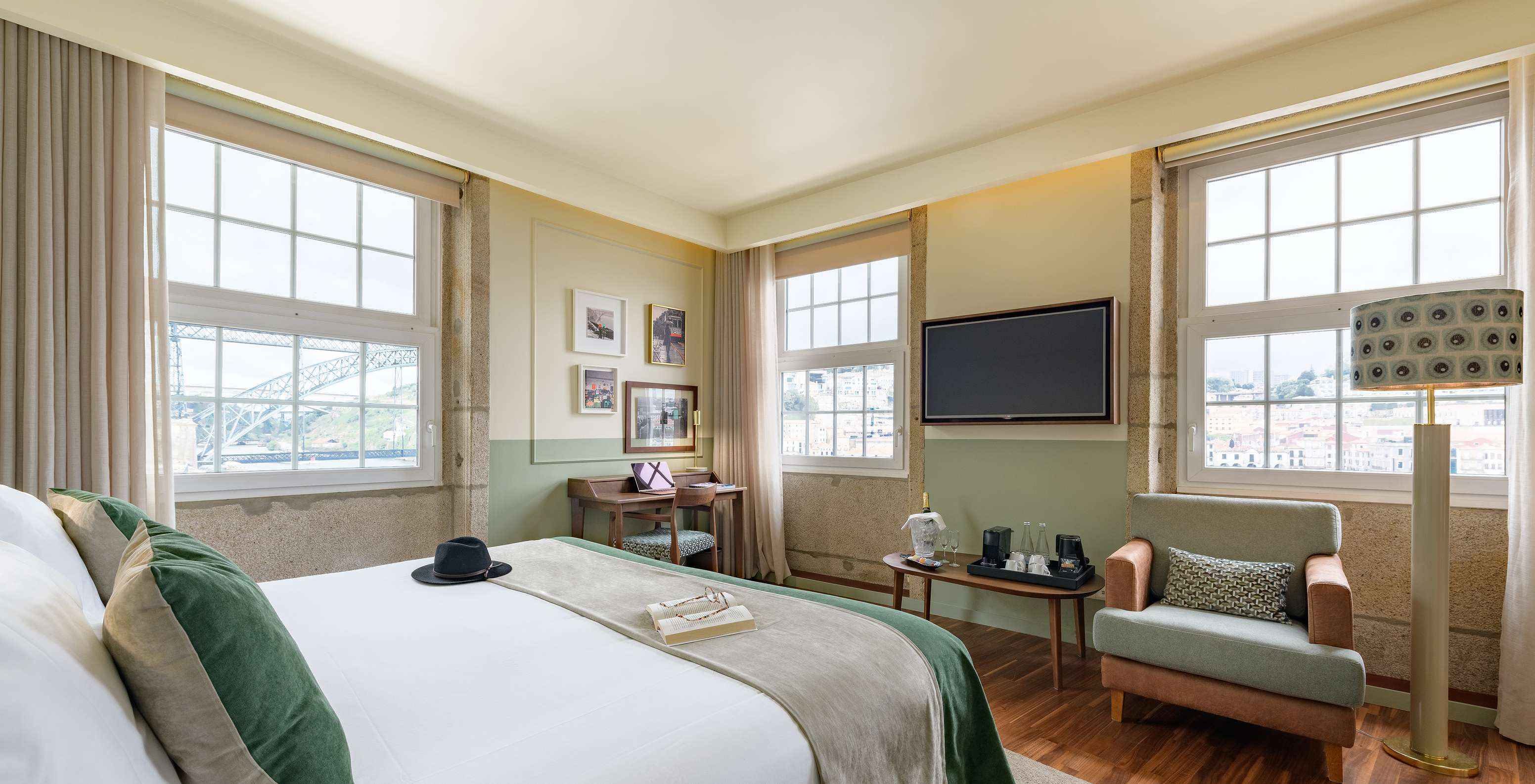 The Vintage Grand View room at Pestana Vintage Porto has three large windows with view of the Douro River and a double bed