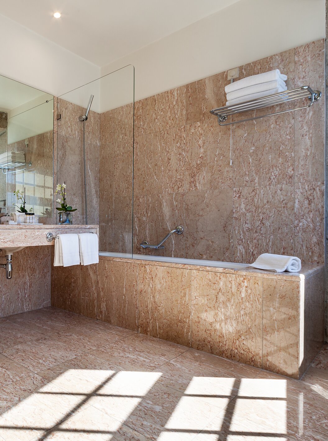 The Plaza room at Pestana Vintage Porto has a bathroom with bathtub, two bathrobes, sink and hairdryer