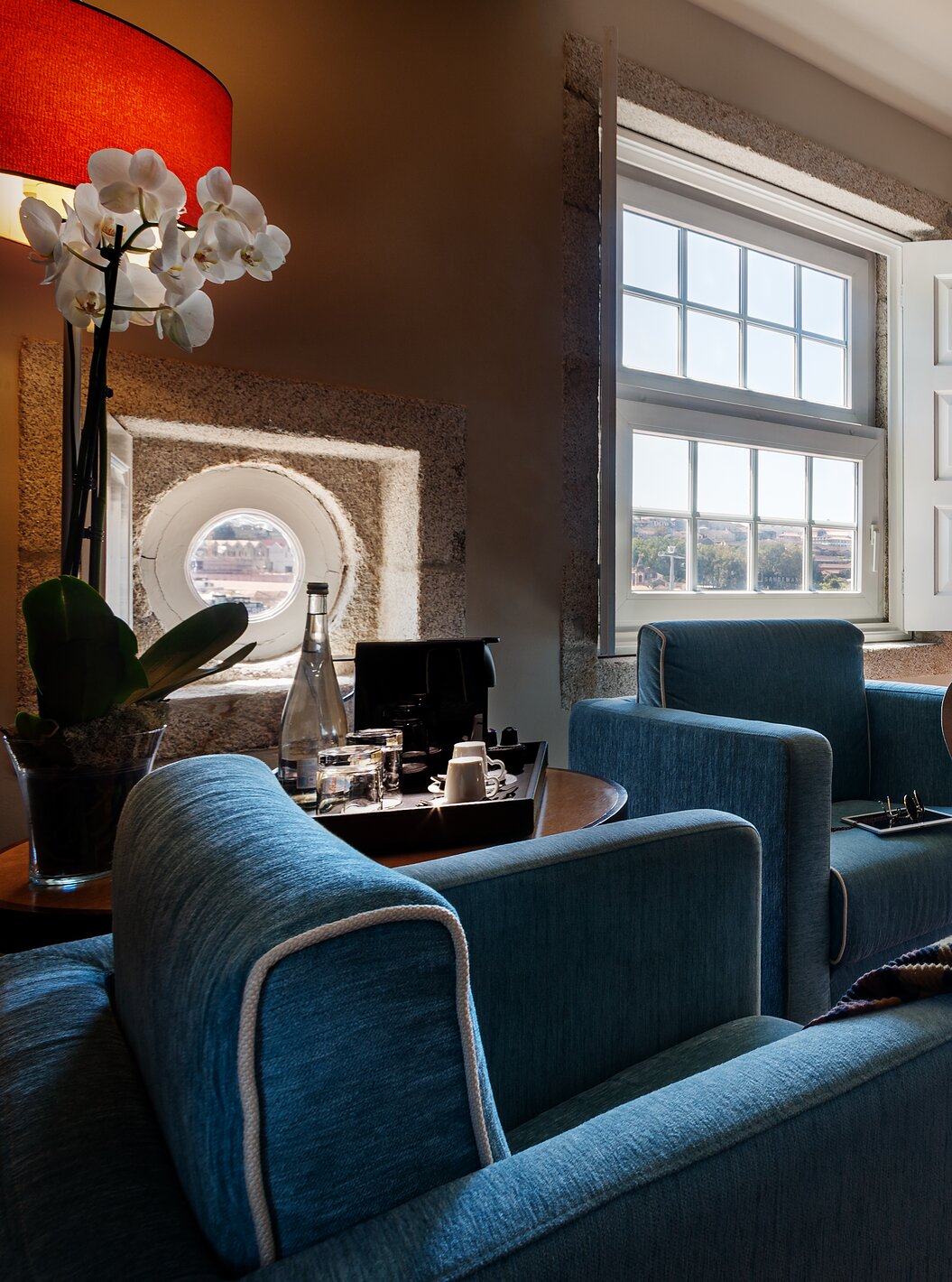 The Plaza room at Pestana Vintage Porto has two beds, two armchairs, a wooden beam on the ceiling and two large windows