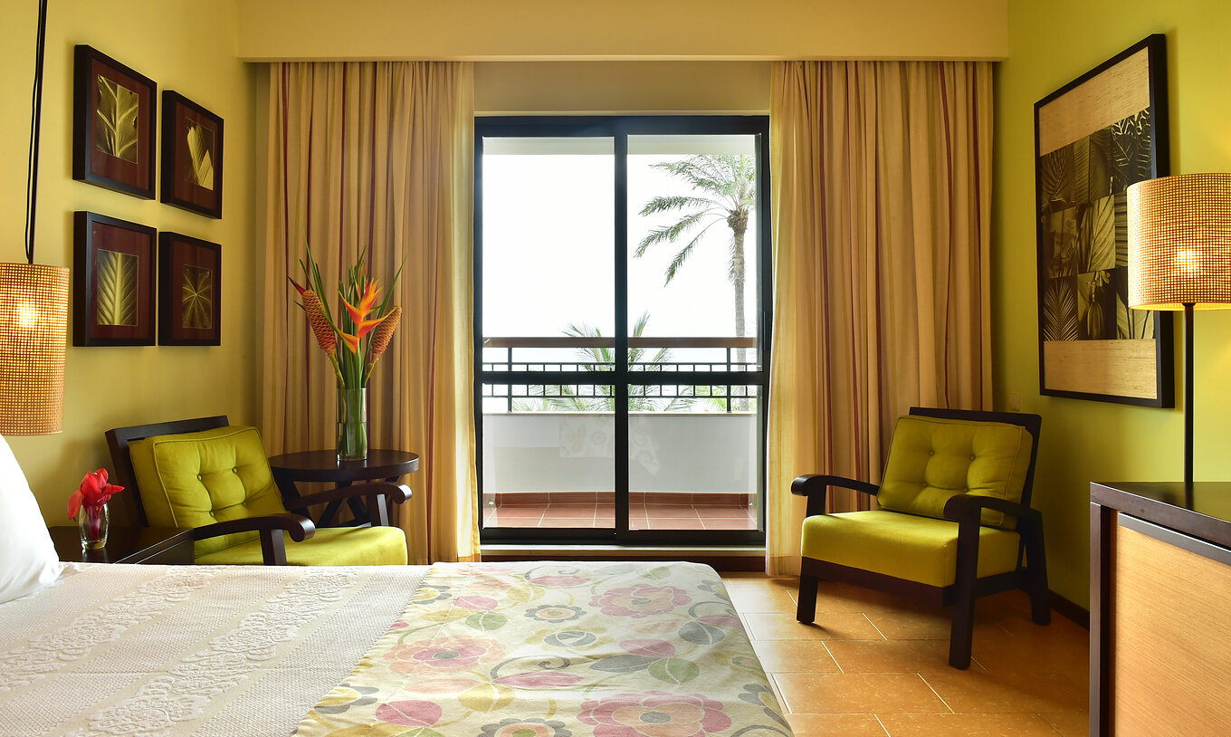 The Sea View Room of Pestana São Tomé has a balcony where you can enjoy an amazing view of the sea and palm trees