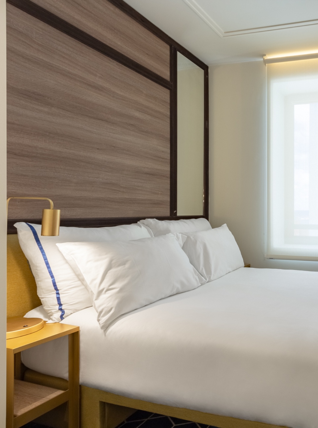 The Small Double Room at Pestana CR7 Gran Vía Madrid has a double bed, a window, and a yellow bedside table