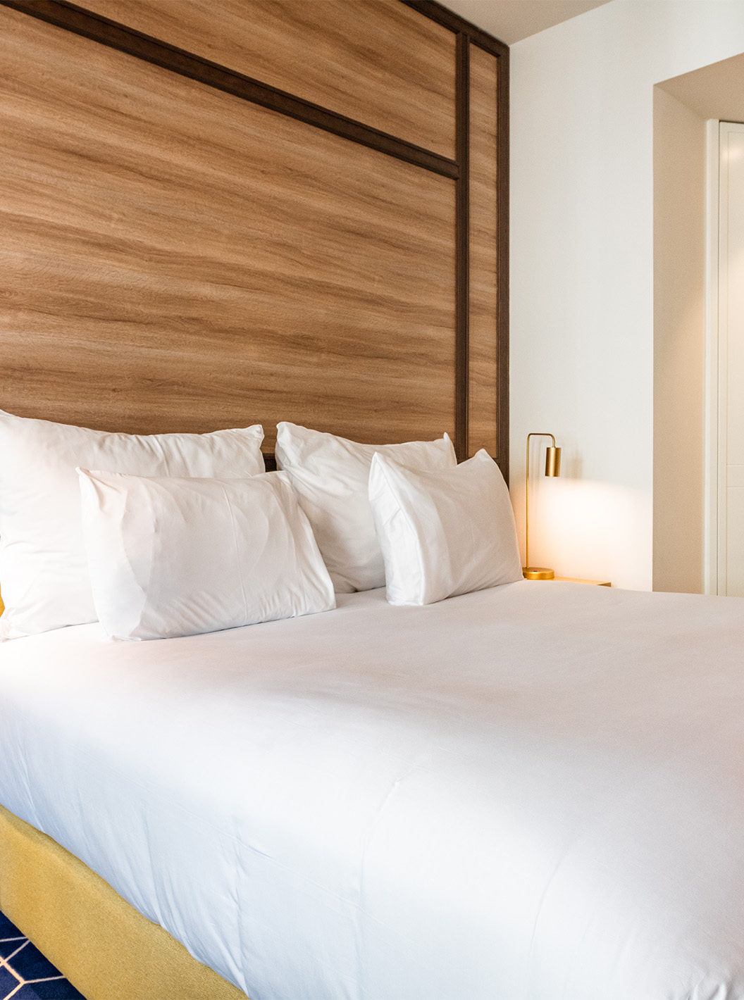 The Fantastic 7 Room at Pestana CR7 Gran Vía Madrid features a double bed, bedside table, lamps, mirror, and wardrobes