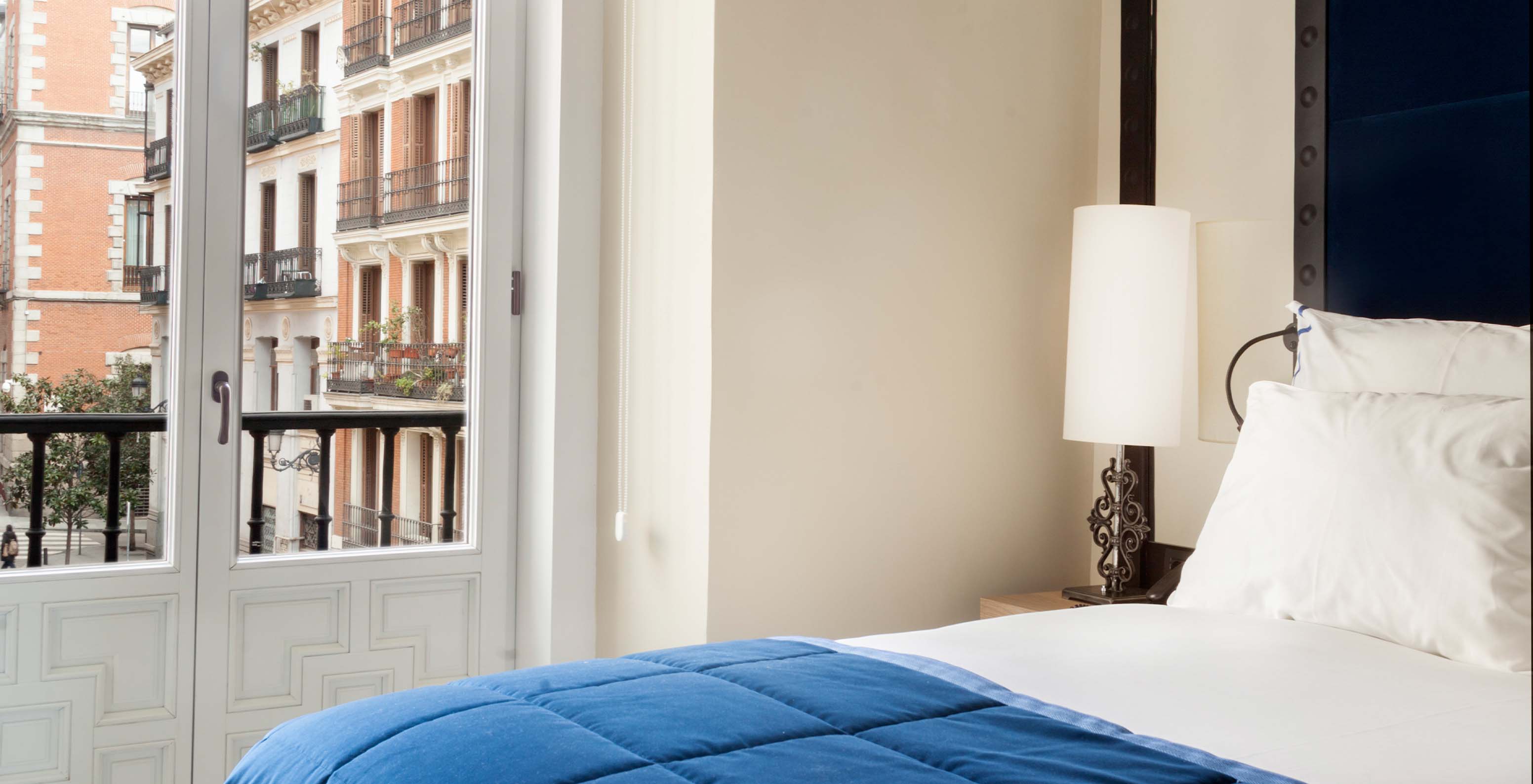 The Superior Plaza Mayor at Pestana Collection Plaza Mayor has a bed, a lamp on the bedside table and a window