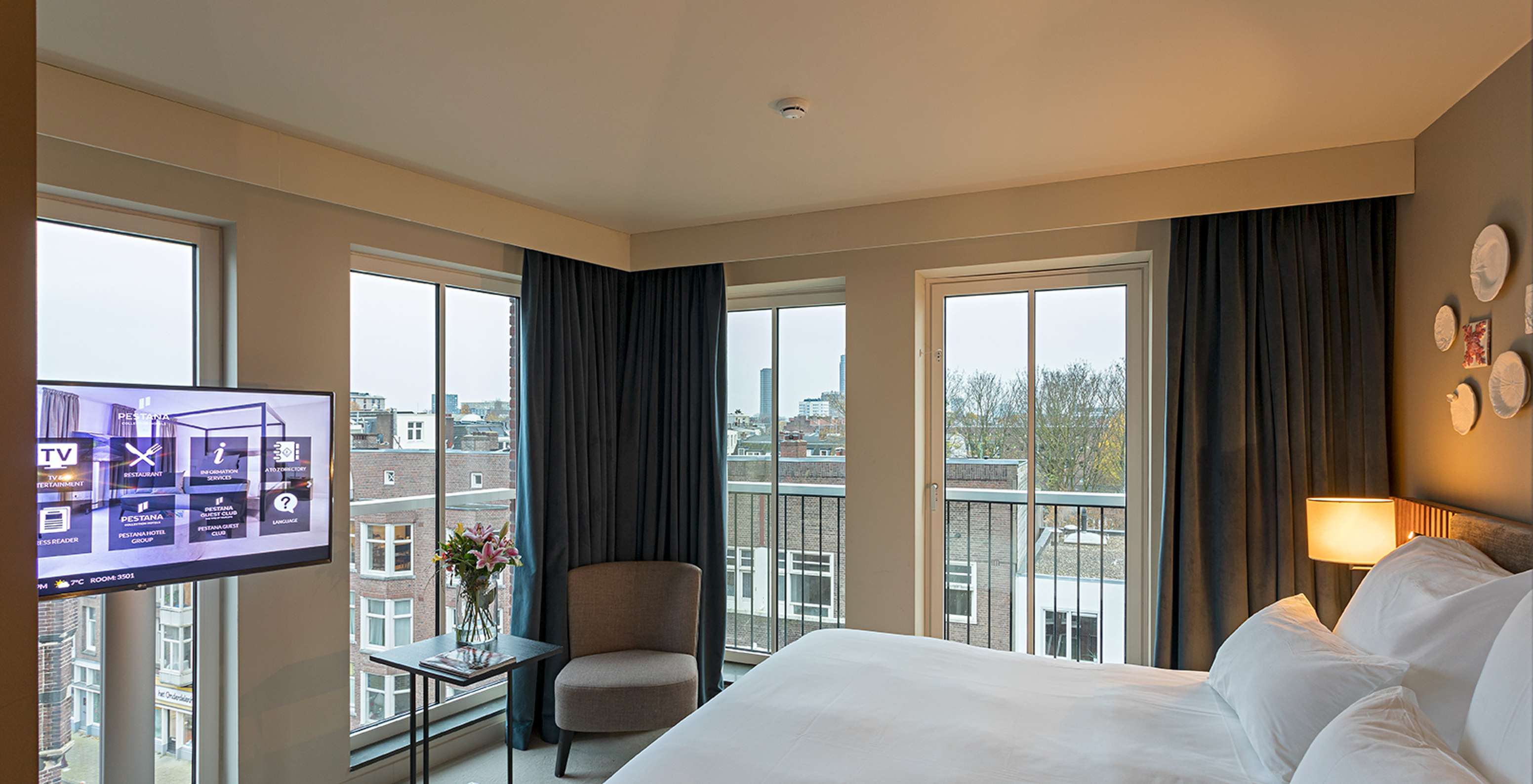 Classic Studio room at Pestana Amsterdam Riverside has a double bed, a lamp and windows overlooking the street