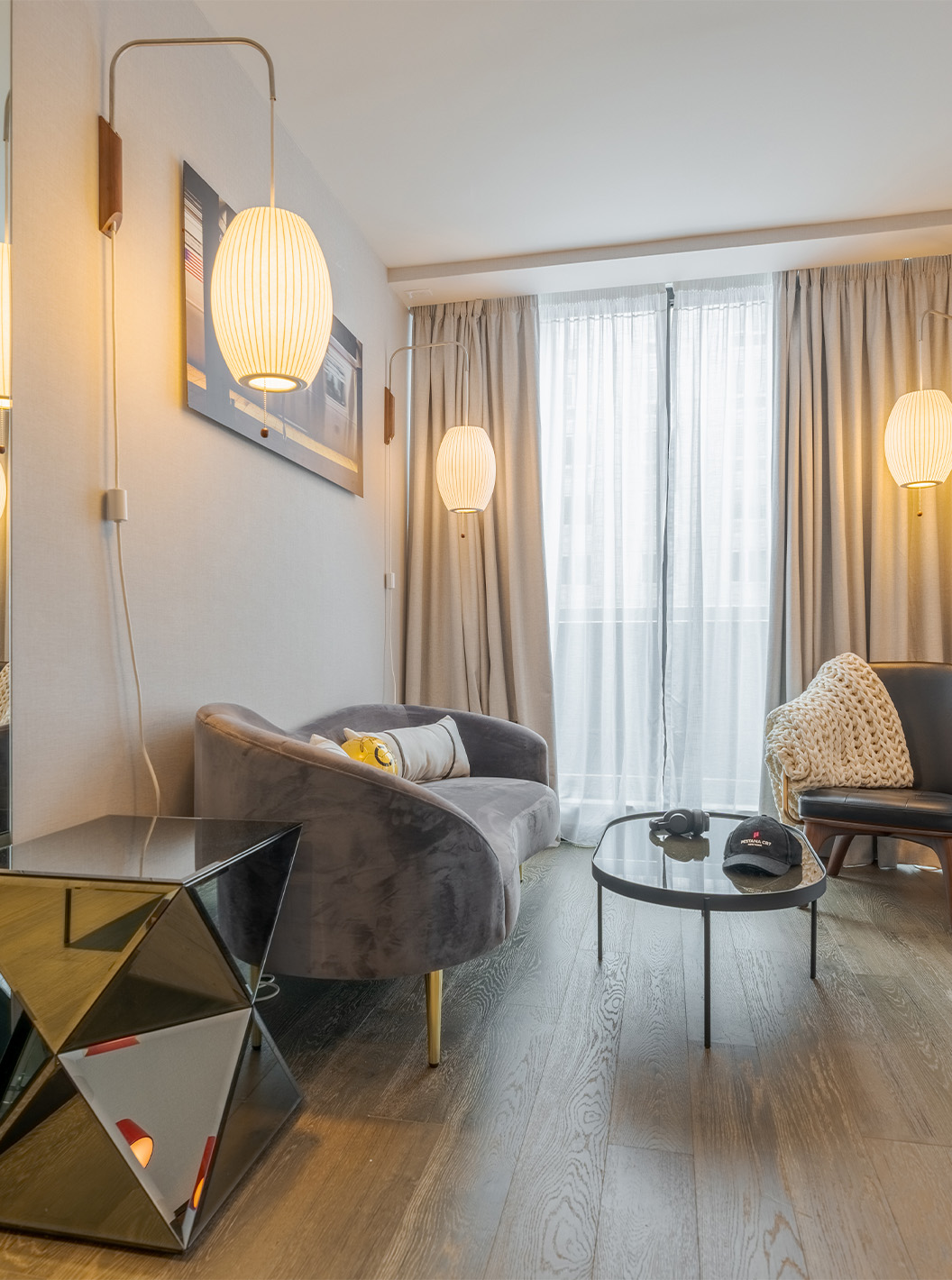 The Junior Suite with Balcony and View at Pestana CR7 Times Square has a living room with a sofa, large windows, and a chair