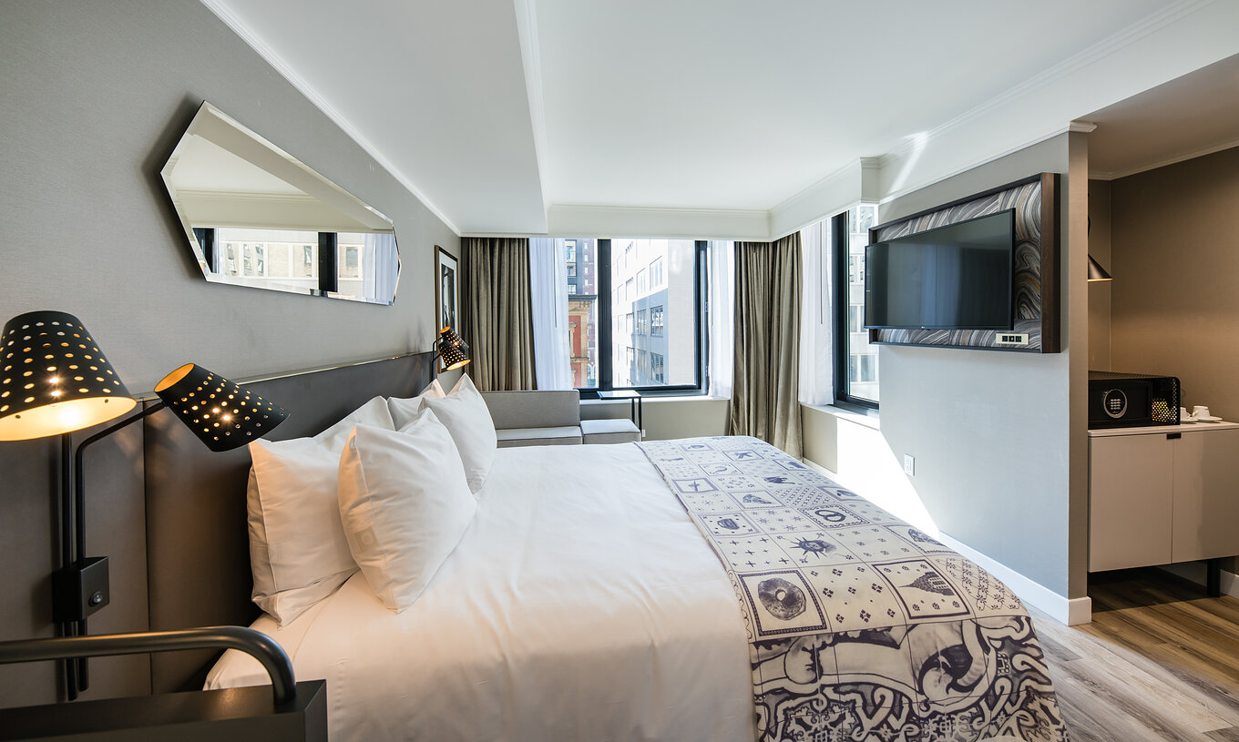 The Superior room at Pestana Park Avenue has a double bed, with TV, mirror and view of the city