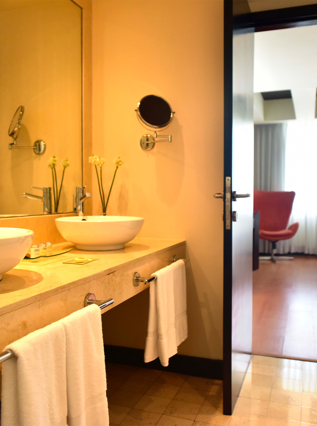 The Presidential Suite at Pestana Caracas has a bathroom with two sinks, a mirror, and a magnifying mirror