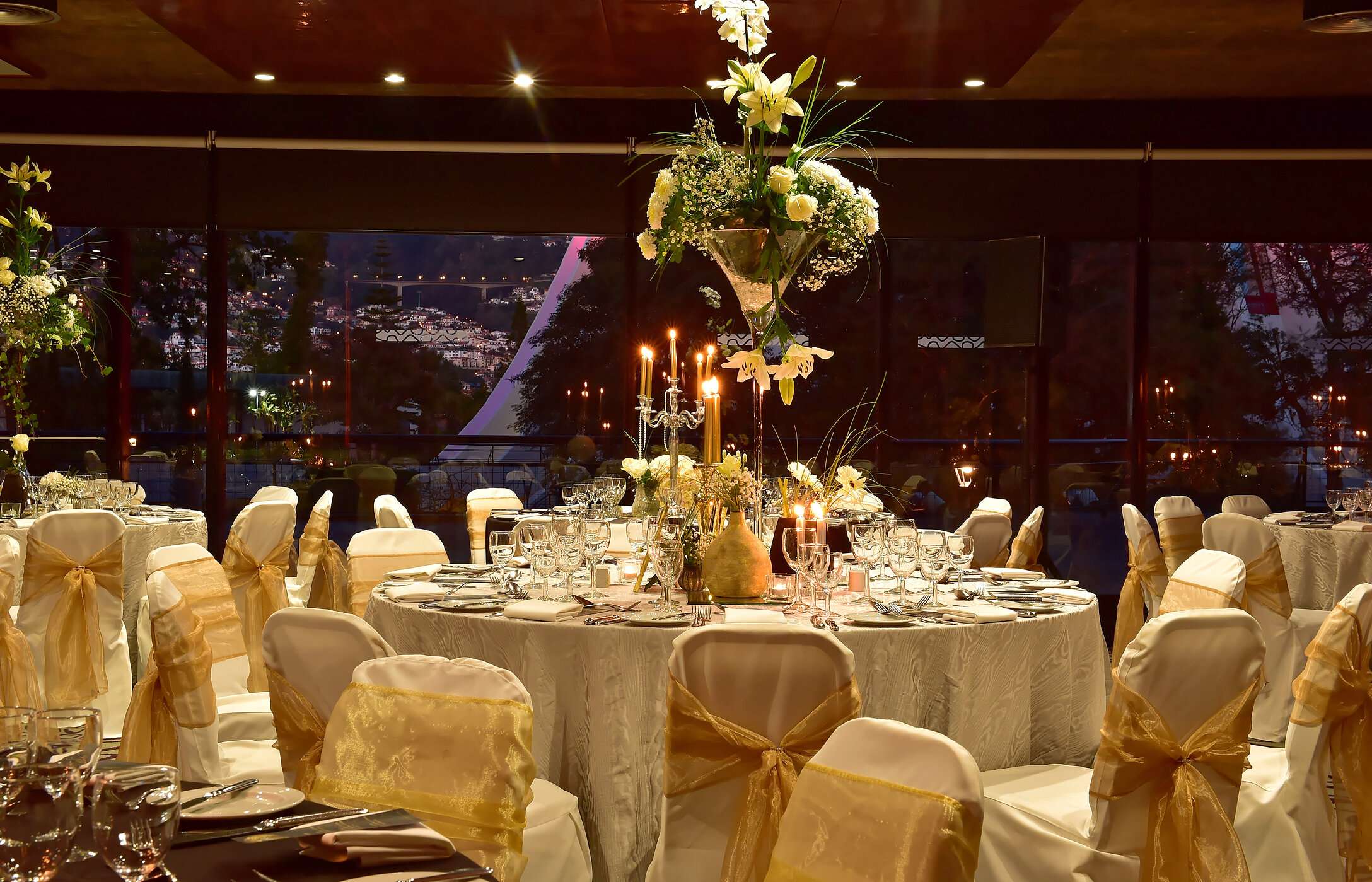 Celebrate at Pestana Hotel Group with a gala dinner, round tables, and floral arrangements