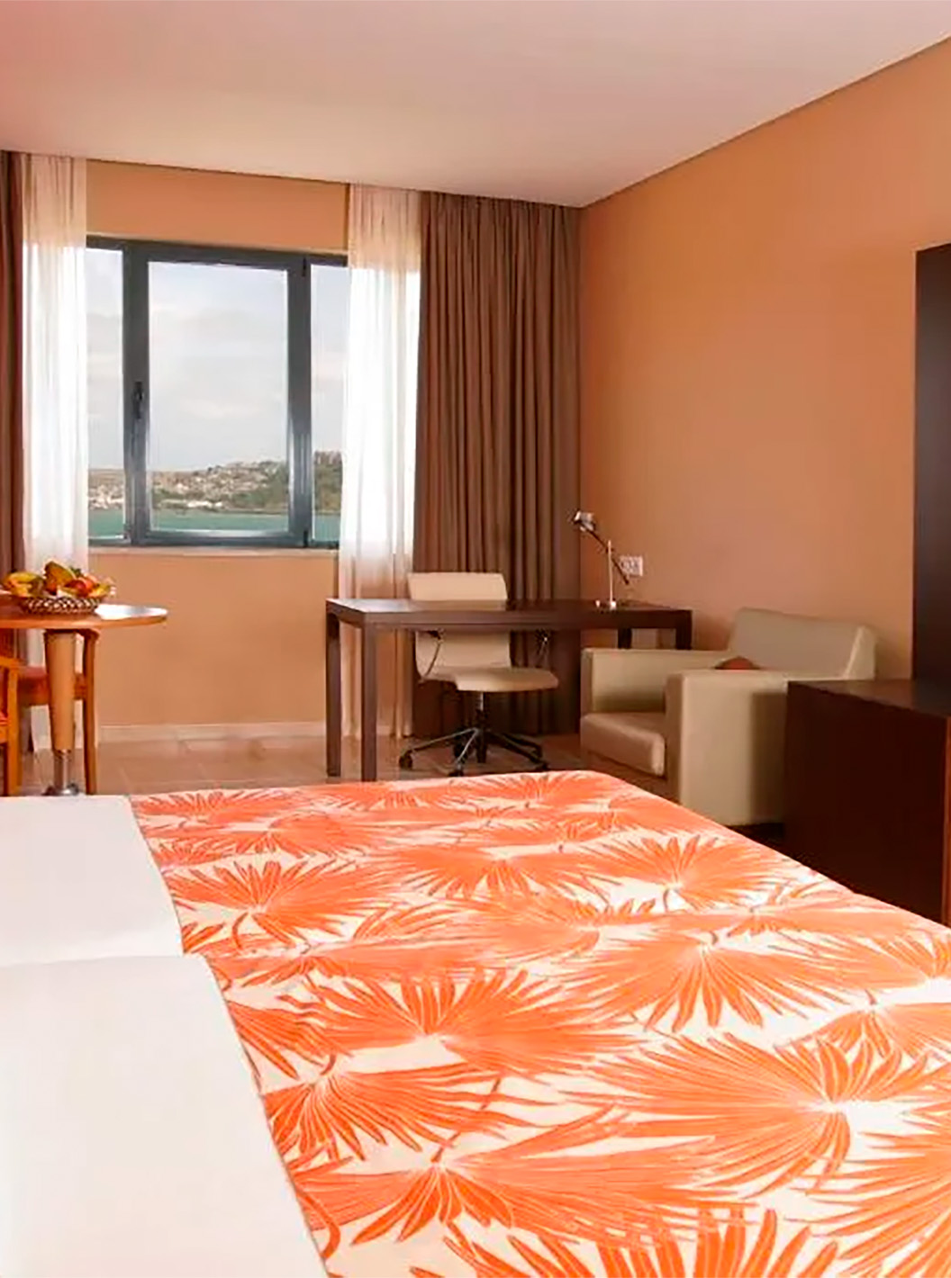 La Suite Premium del Pestana Tropico cuenta con dos camas individuales, escritorio con silla, una mesa y vista al mar