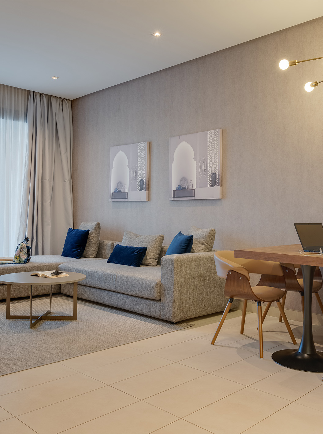 La Family Suite Premium Superior del Pestana Casablanca tiene un sofá gris grande con chaise longue cerca de la ventana