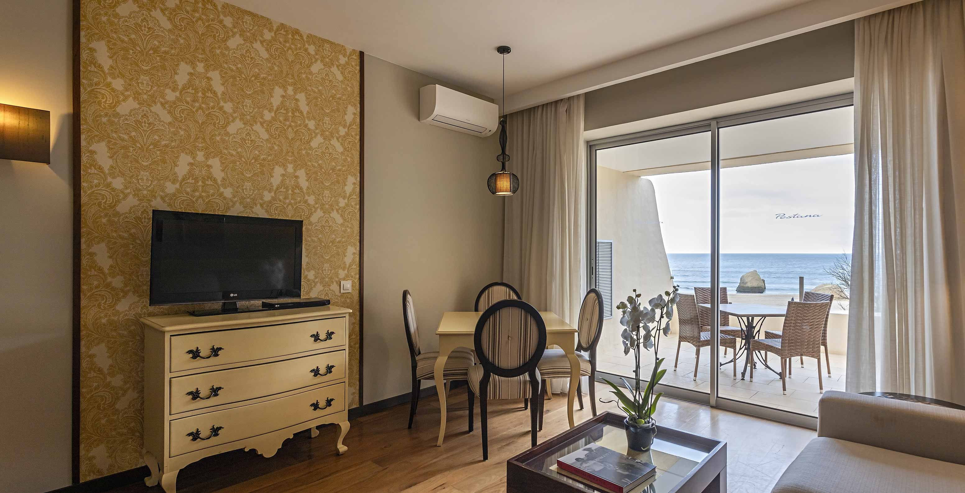 La Cliff Suite T1 en Pestana Alvor Praia tiene una sala de estar con televisión y un balcón con una mesa y vistas al mar