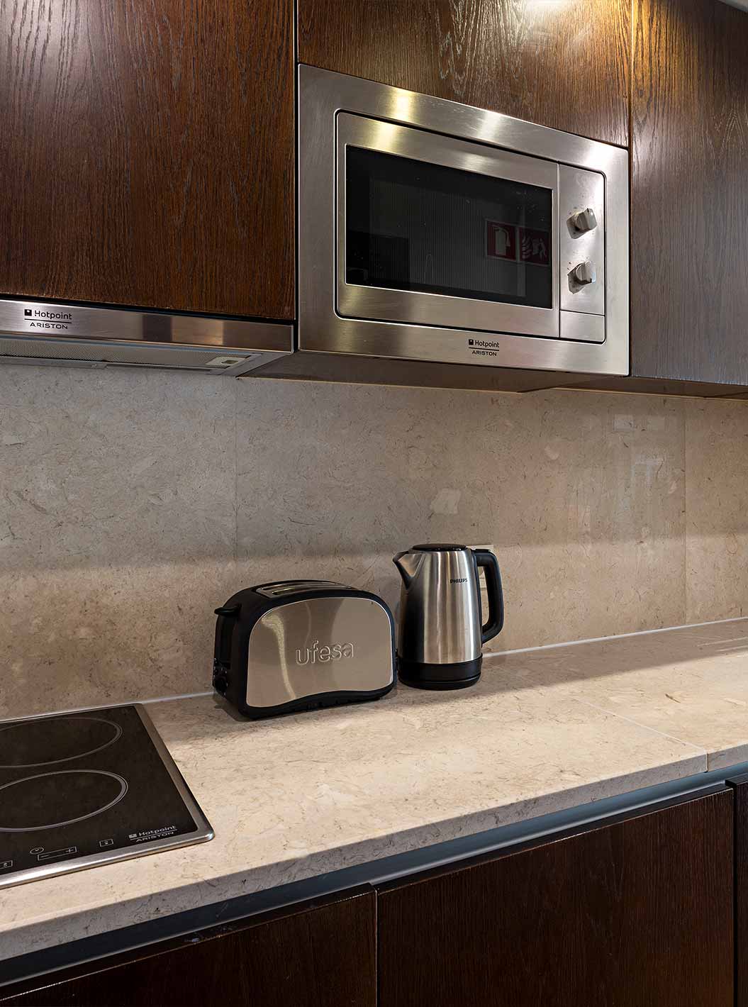 La Cliff Studio en Pestana Alvor Praia tiene una cocina equipada en madera oscura y piedra, con una estufa y un microondas