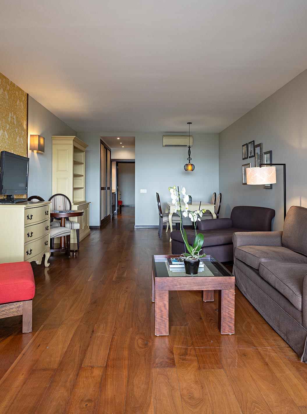 La Cliff Suite T2 en Pestana Alvor Praia tiene una sala de estar con dos sofás, papel pintado, una televisión y una mesa