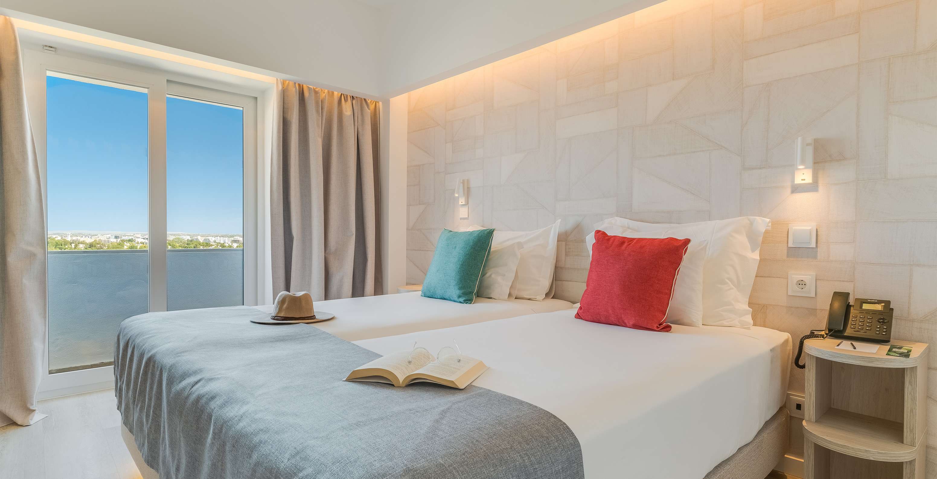 El Cuarto Clásico Vista Jardín del Pestana Blue Alvor Beach tiene dos camas con sábanas blancas y almohadas coloridas