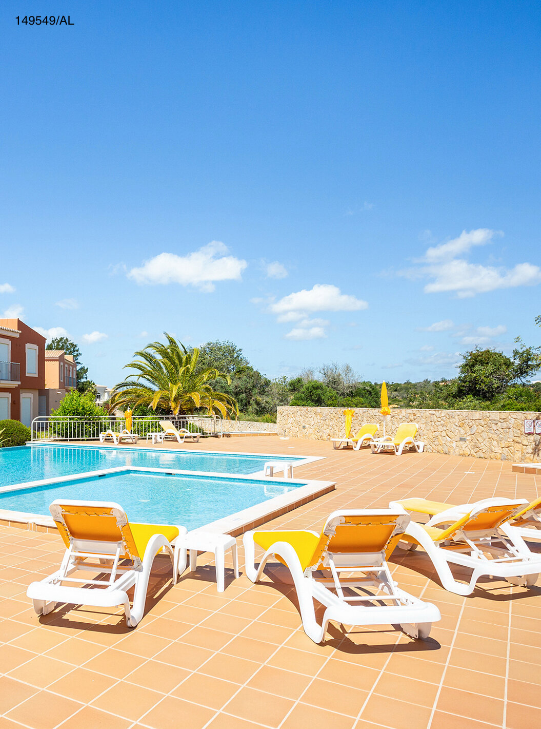 El apartamento Pestana Carvoeiro Golf T2 Superior tiene un patio exterior con piscina y tumbonas amarillas