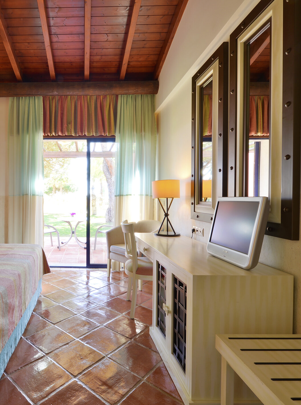 La Suite Vista Jardín Vila Sol del Pestana Vila Sol - Vilamoura tiene dormitorio con cama doble, espejo y ventana con balcón