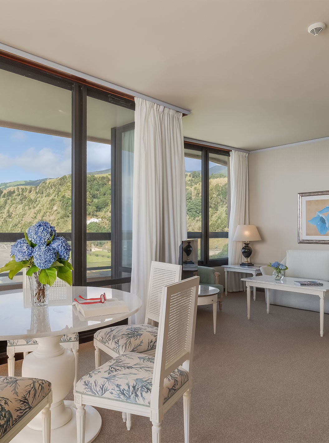 La Suite del Pestana Bahia Praia tiene sala con vista a la playa junto al hotel y a la naturaleza verde