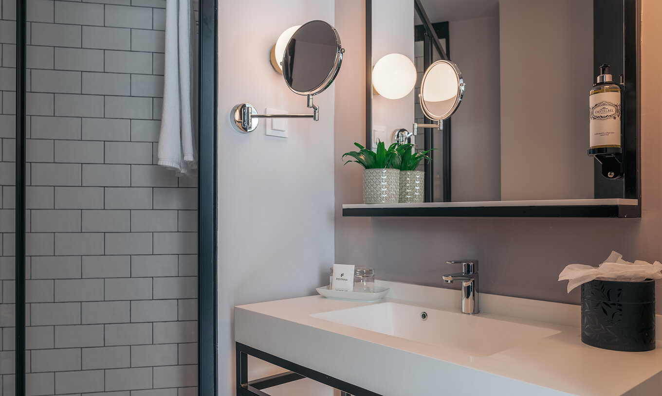 El Double Superior del Pestana Lisboa Vintage tiene un baño con lavabo con dos espejos y una ducha lateral