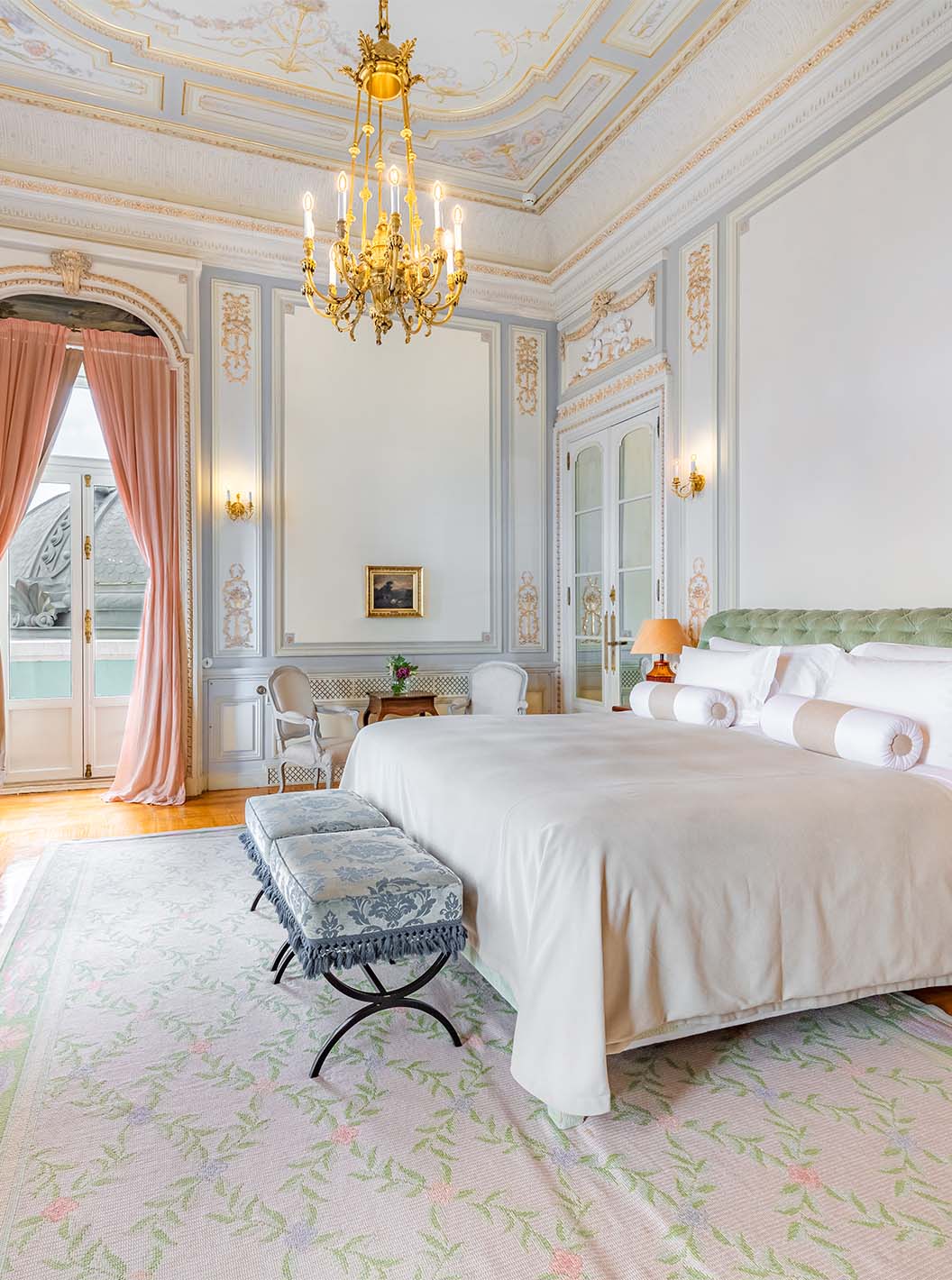 La Suite D. Manuel/ D. Luís Filipe del Pestana Palace Lisboa tiene un dormitorio grande y lujoso con cama y candelabro dorado