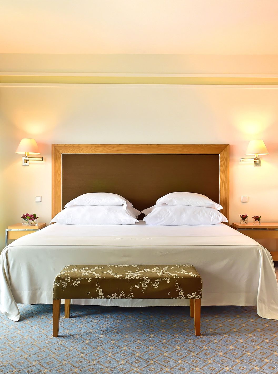 La Junior Suite del Pestana Carlton Madeira tiene cama de matrimonio con un banco al pie y un armario con espejos