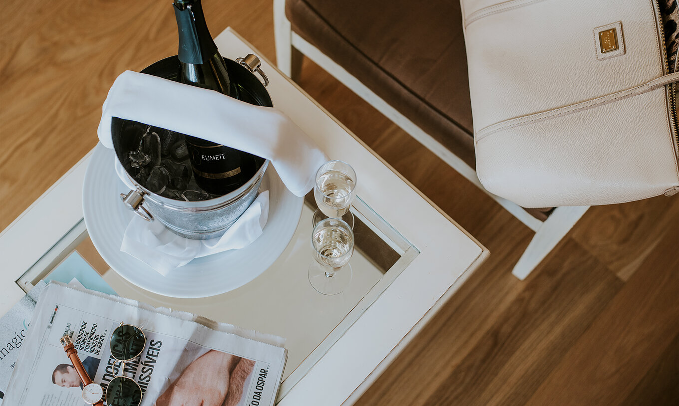 El Apartamento T2 del Pestana Madeira Beach Club tiene una mesa con champán en hielo, periódicos y una silla