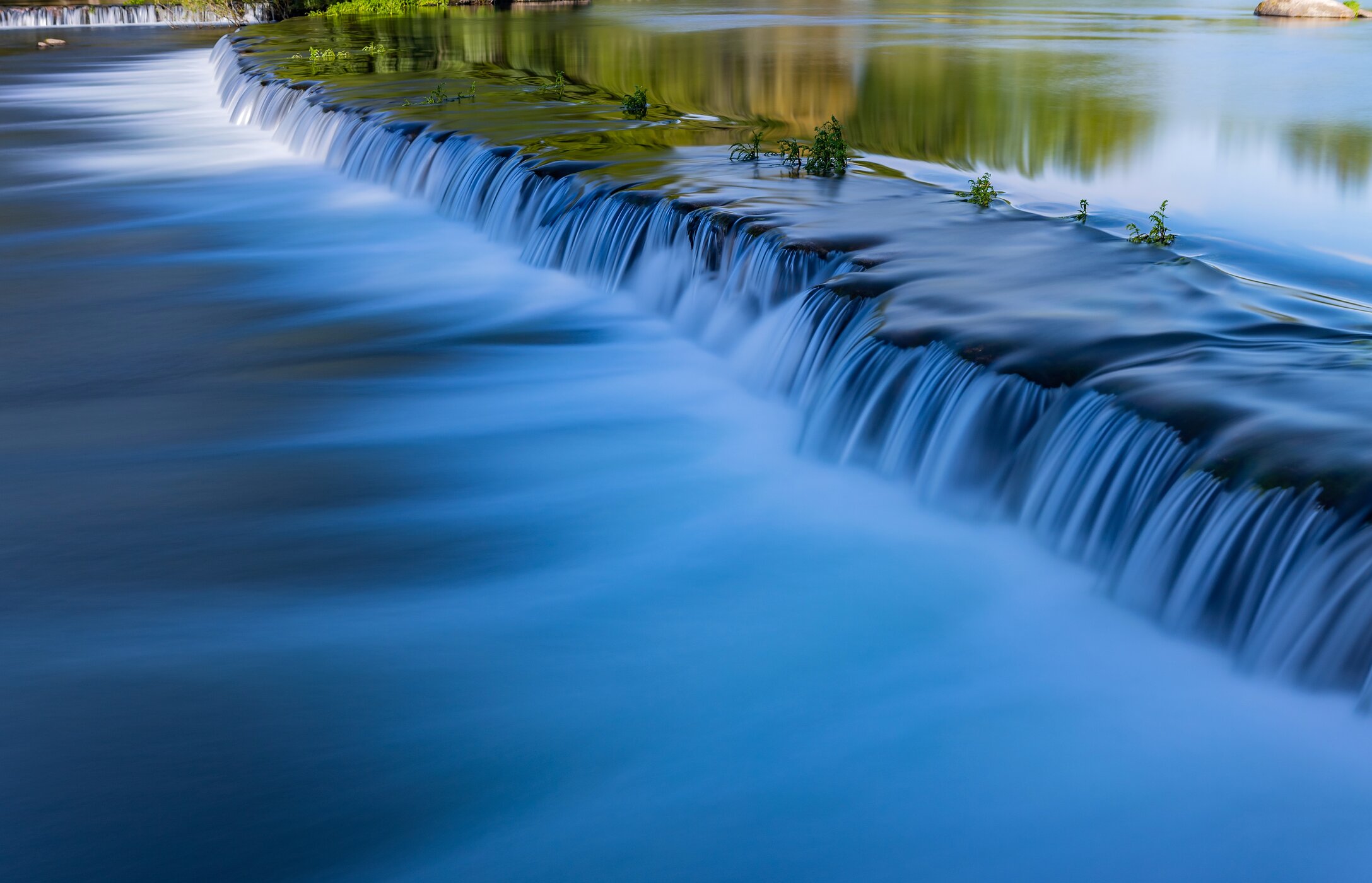 Vista panorámica de la playa de Adaufe, con aguas cristalinas, rodeada de rocas y vegetación