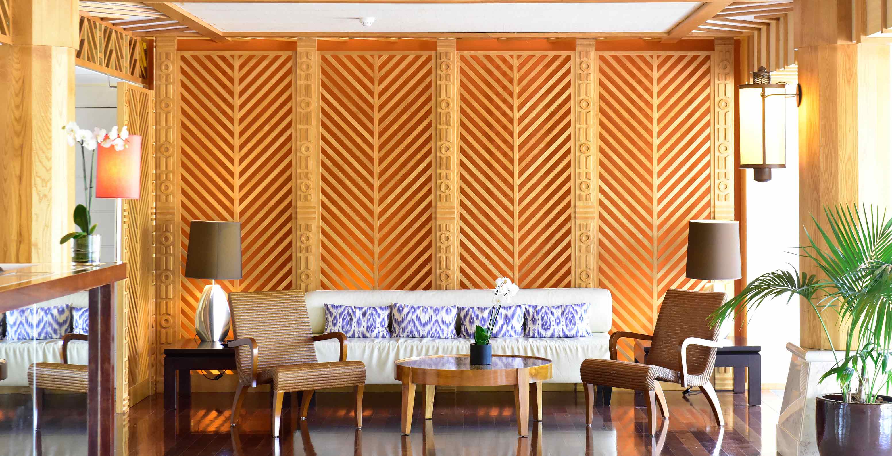 Sofá con cojines, sillones y mesa centro en salón decoración madera en Pestana Porto Santo