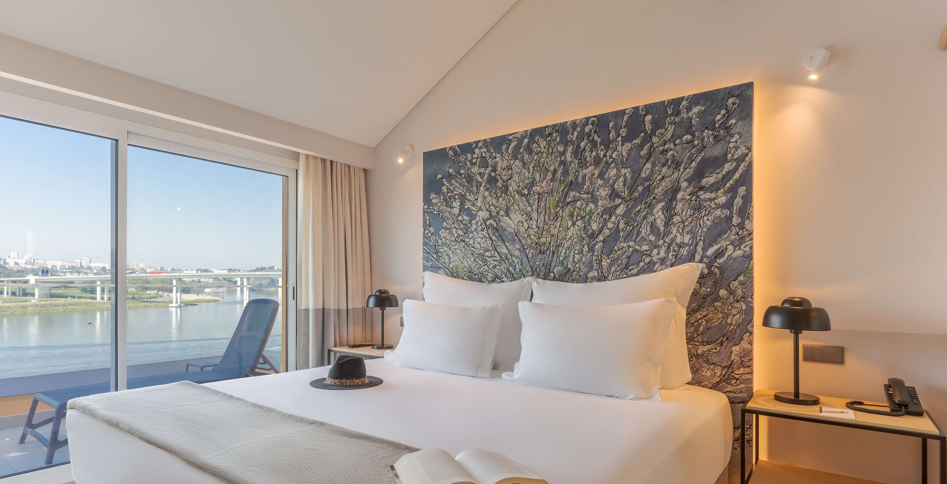 La Suite Douro del Pestana Douro Riverside cuenta con una cama de matrimonio con mesa de noche y terraza con vista al río