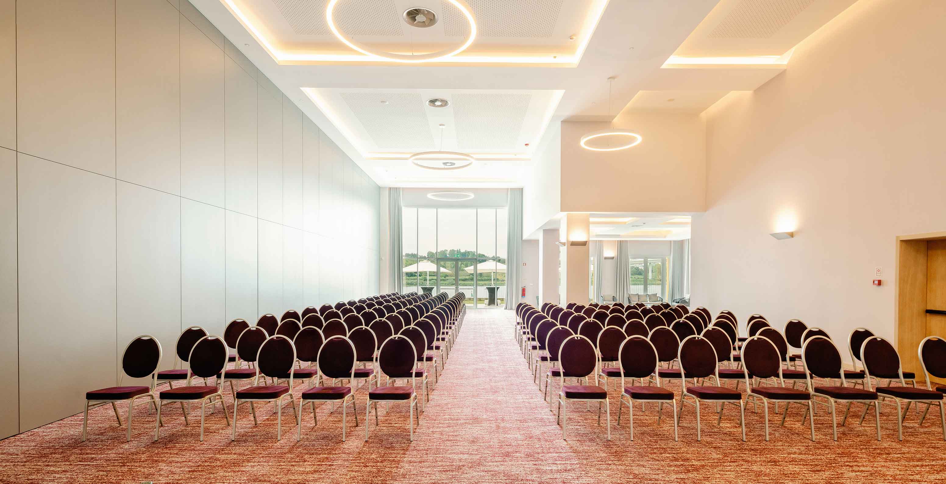 Sala Douro i con sillas y grandes ventanas en el Pestana Douro Riverside Hotel con piscina frente al río Duero