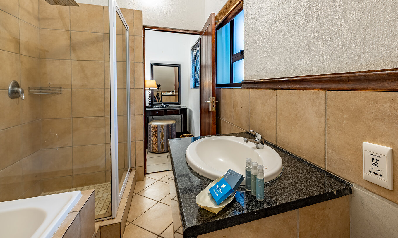 El Quarto Familiar del Pestana Kruger Lodge tiene un baño con bañera, ducha, lavamanos y amenities