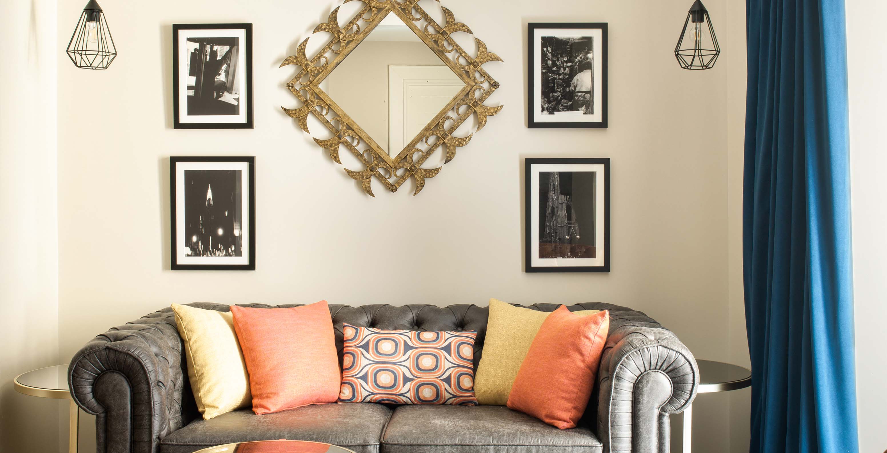 El Deluxe Grand Plaza Mayor del Pestana Collection Plaza Mayor tiene un sofá de dos plazas en gris y cuadros en la pared