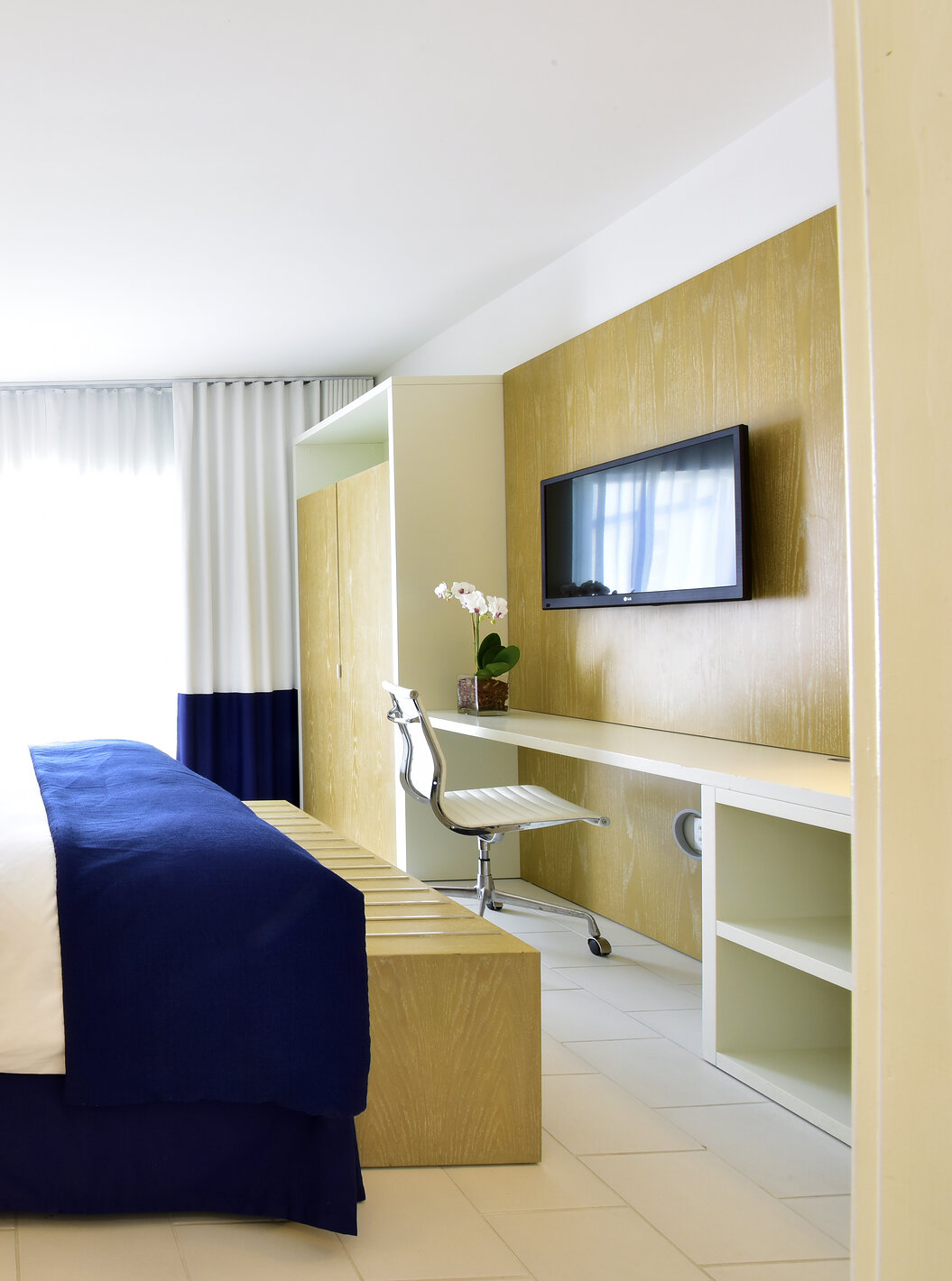La Suite King con Balcón del Pestana Miami es moderna con cama grande y decoración azul y blanca.