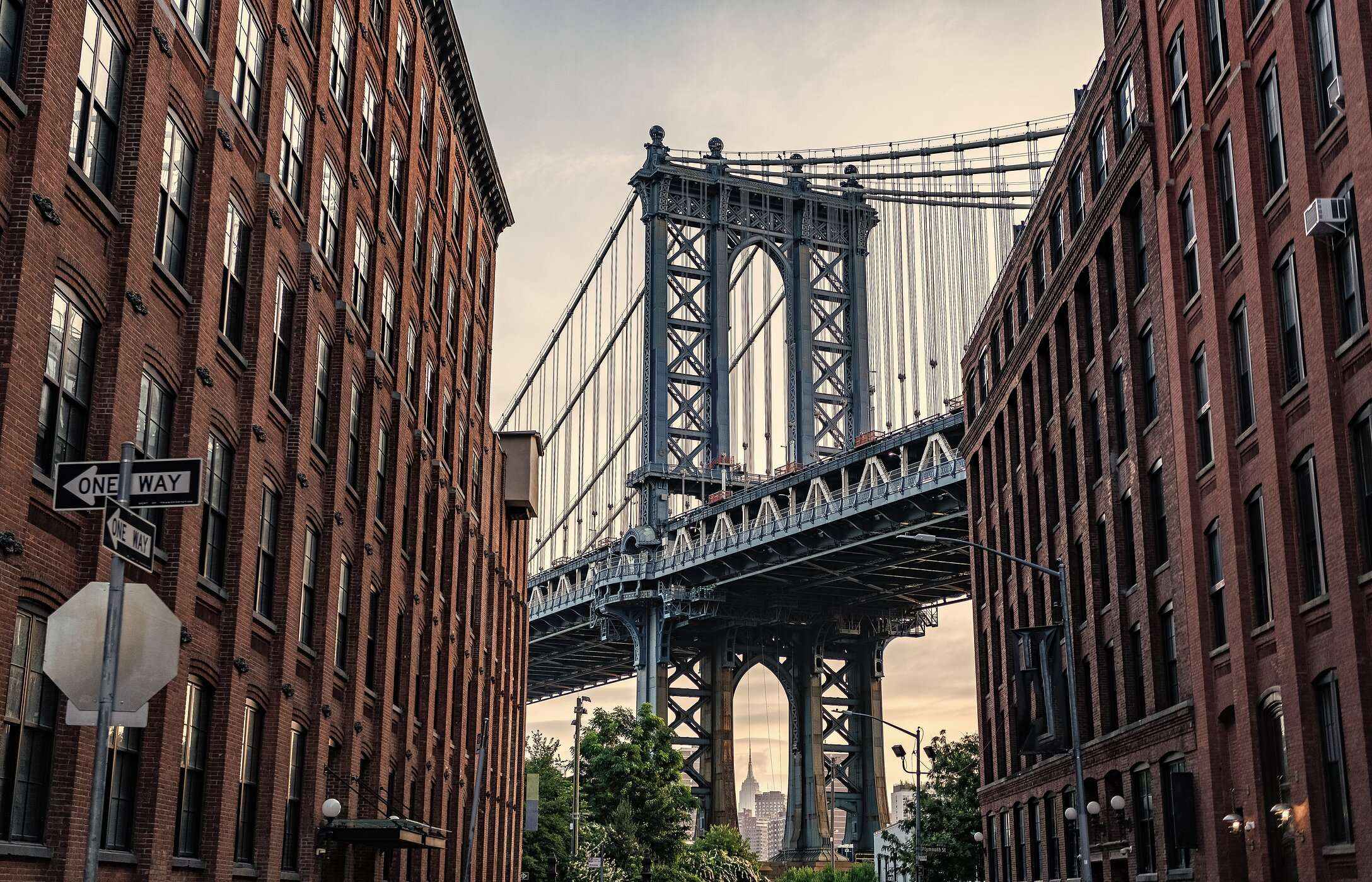 Vista del icónico Puente de Brooklyn, entre edificios, que une Manhattan con Brooklyn en Nueva York