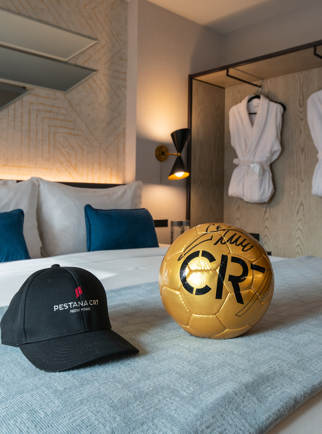 El Deluxe King Room ADA del Pestana CR7 Times Square tiene una cama doble con una pelota y un sombrero de CR7