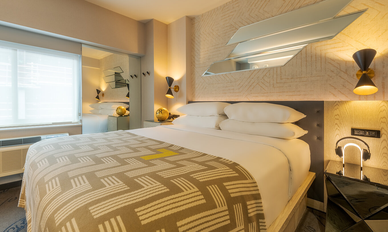 El Comfort ADA del Pestana CR7 Times Square tiene una cama doble con una colcha con el número siete y un armario