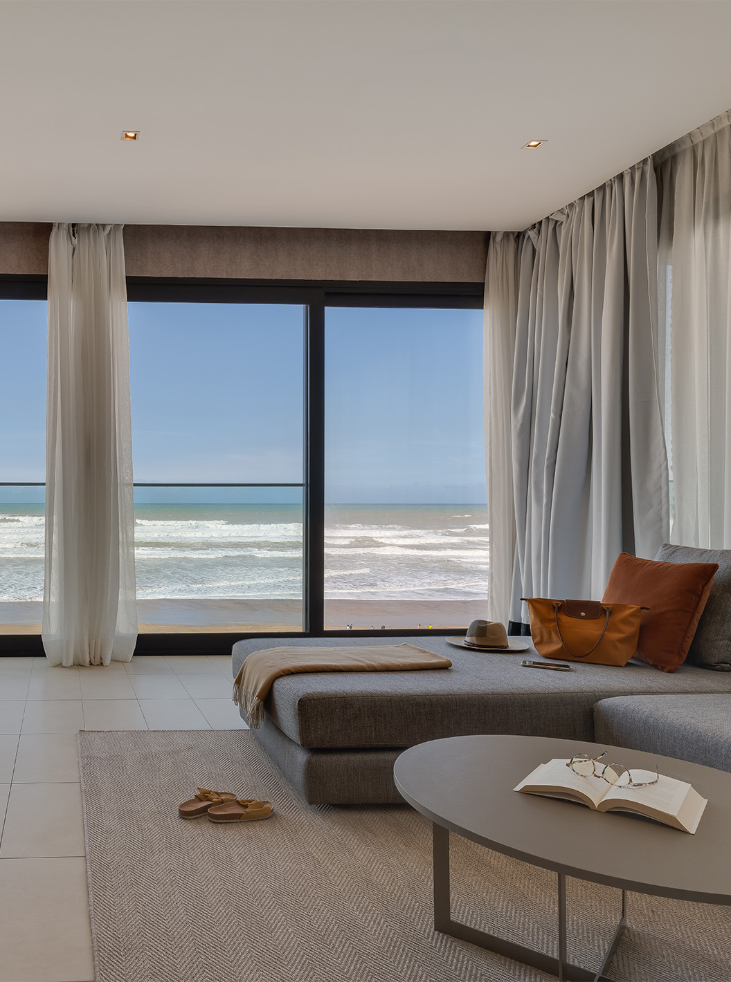 De Familiesuite Corniche van Pestana Casablanca heeft een woonsuite met een bank en een spectaculair uitzicht op het strand.
