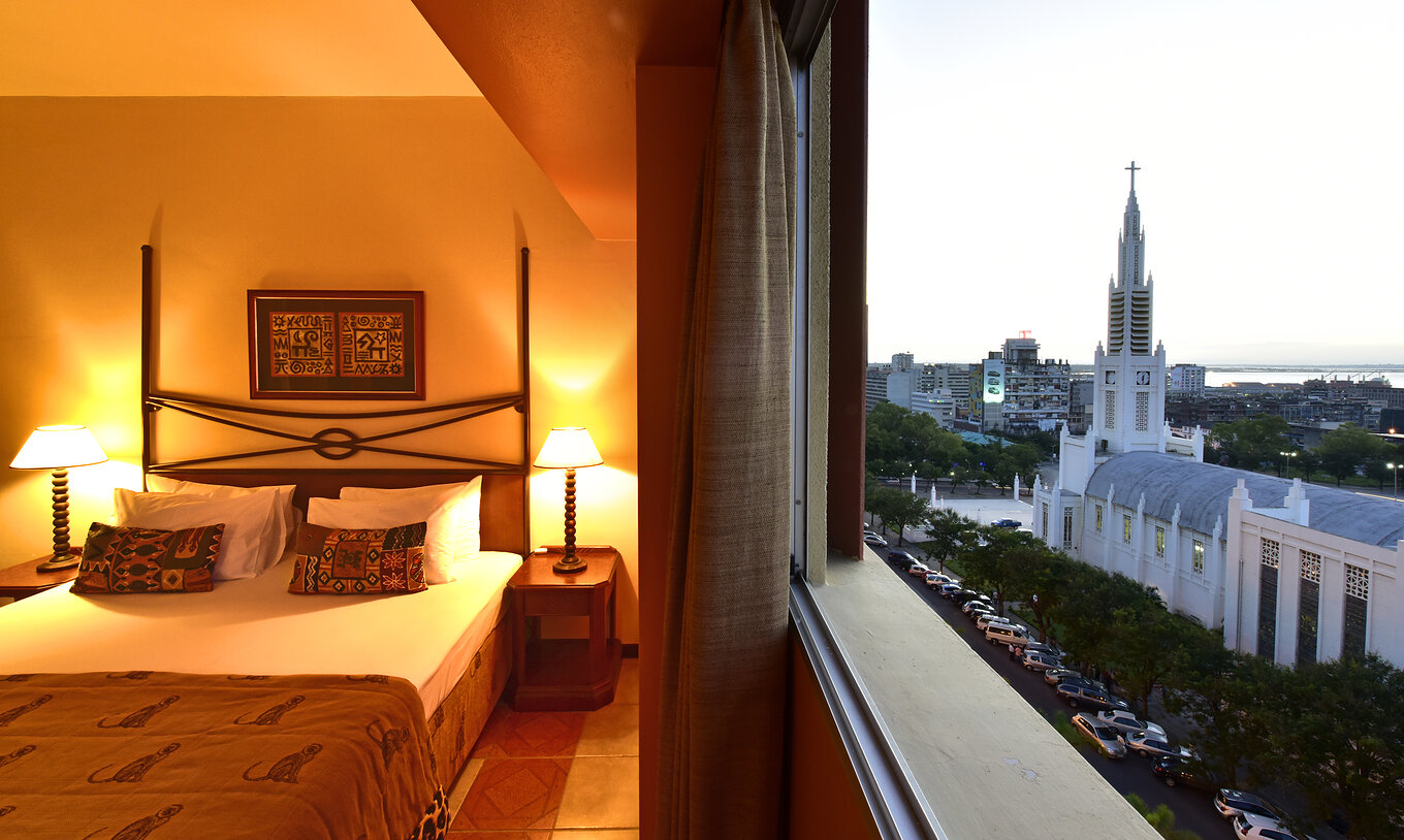 De Executive Suite van Pestana Rovuma heeft naast het bed een raam met uitzicht op de stad Maputo, inclusief de kathedraal