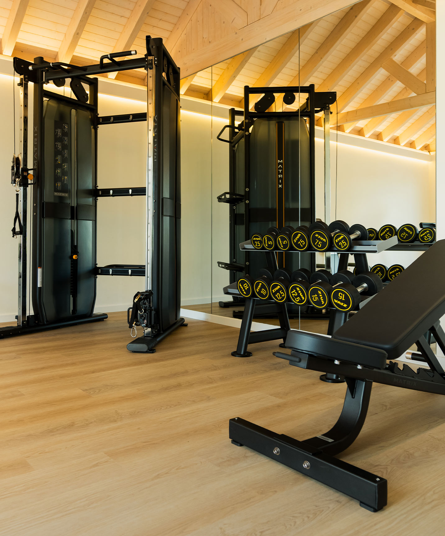 Fitnessruimte met een krachttrainingsmachine en gewichten, gelegen in de villa's van Pestana Comporta Village Residences