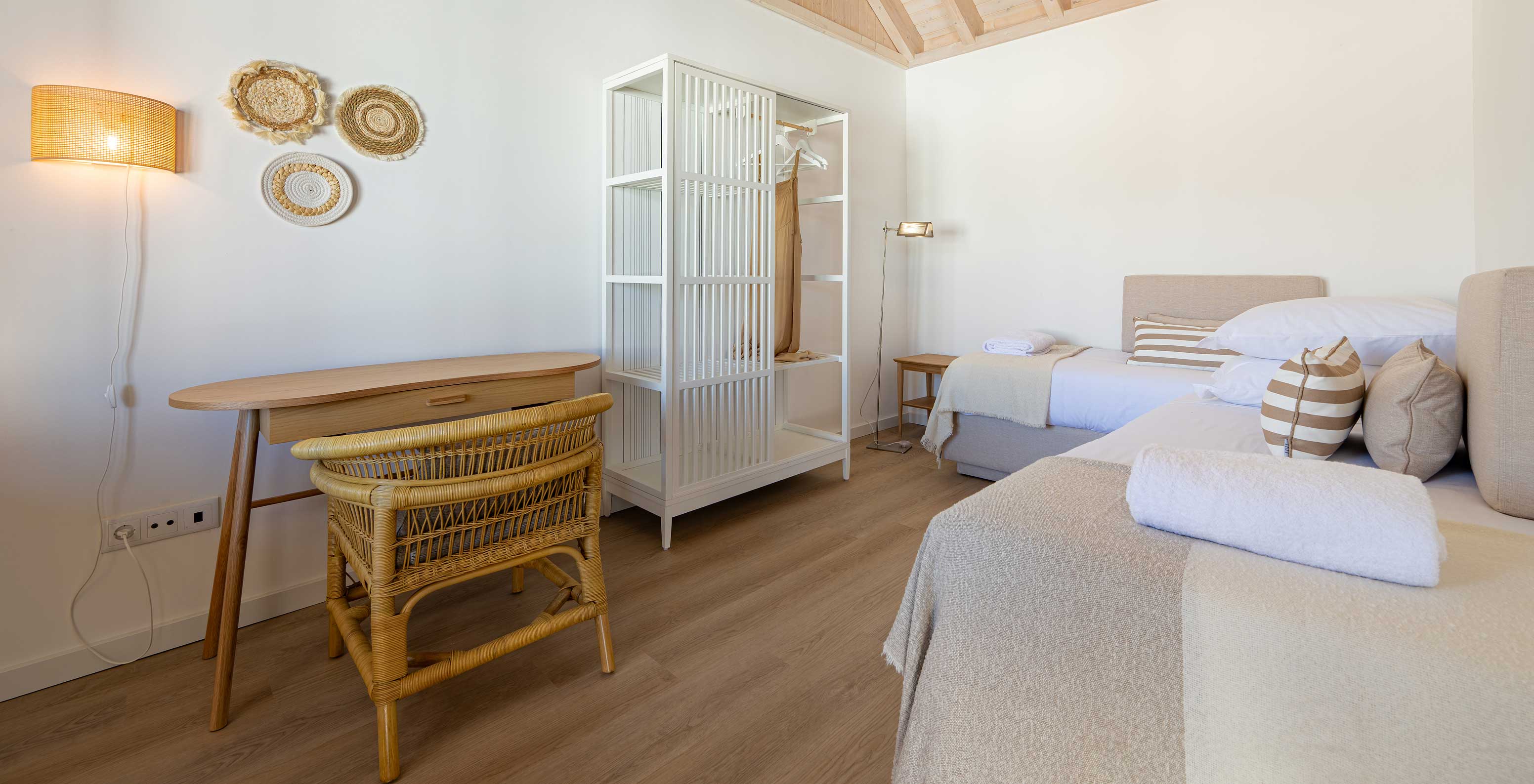 De Premium Villa bij Pestana Comporta Village Residences heeft een slaapkamer met een bed, een tafel en een rieten stoel