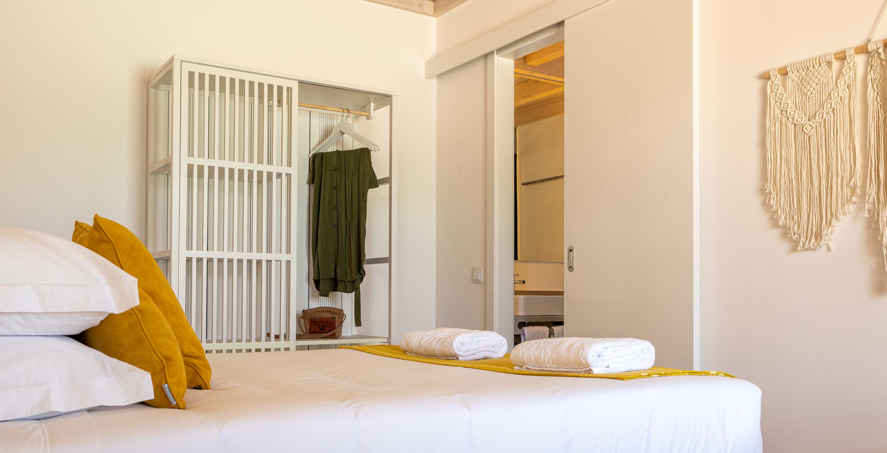 De Premium Villa bij Pestana Comporta Village Residences heeft een minimalistische slaapkamer met een bed en een bank