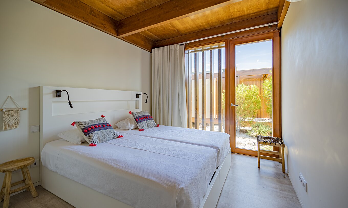 De Tree Villa met Privézwembad van Pestana Tróia Eco Resort heeft een tweepersoonsbed en een raam van vloer tot plafond