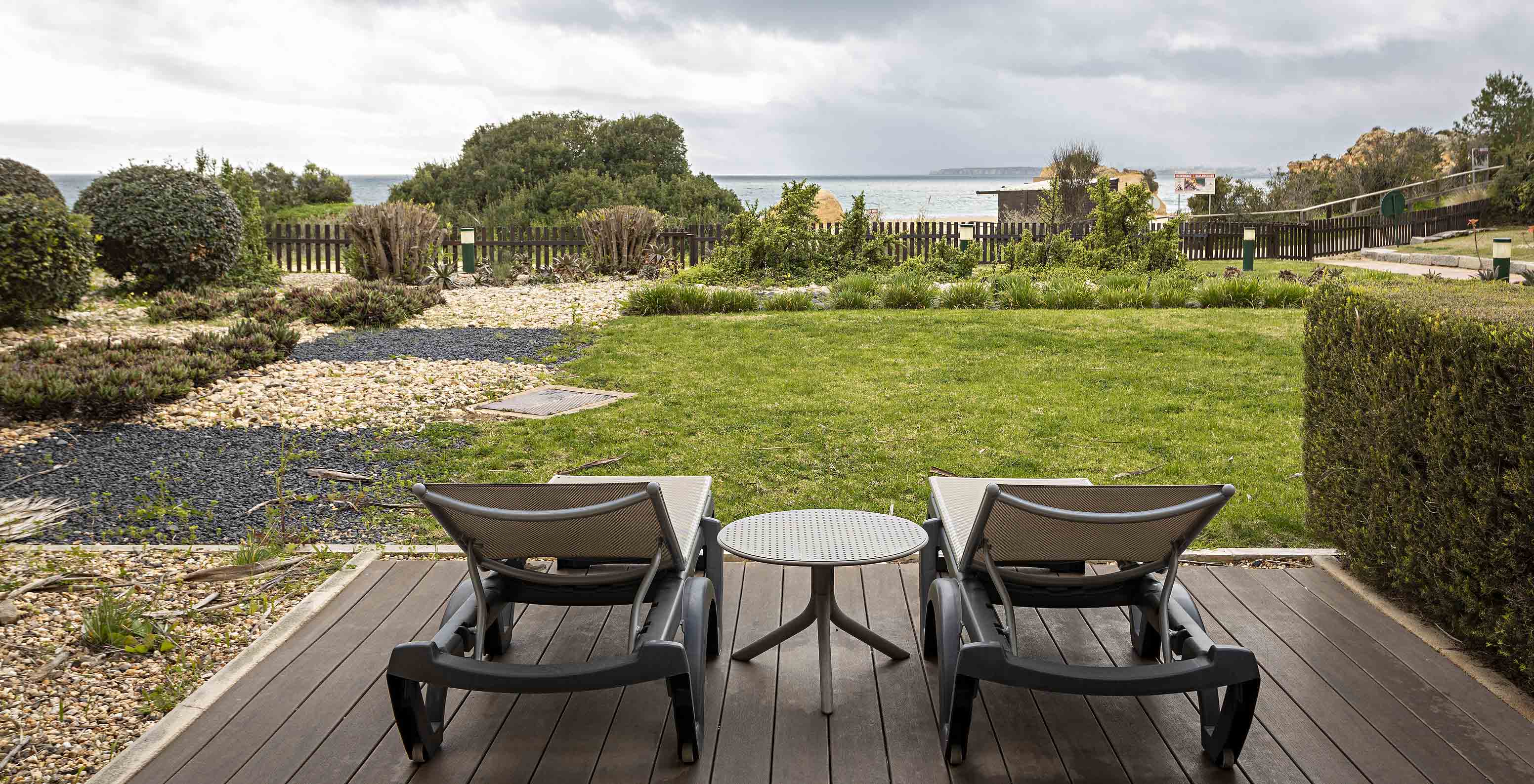 De Cliff Suite T2 in Pestana Alvor Praia heeft een tuin met gras en begroeiing, twee ligstoelen en uitzicht op het strand
