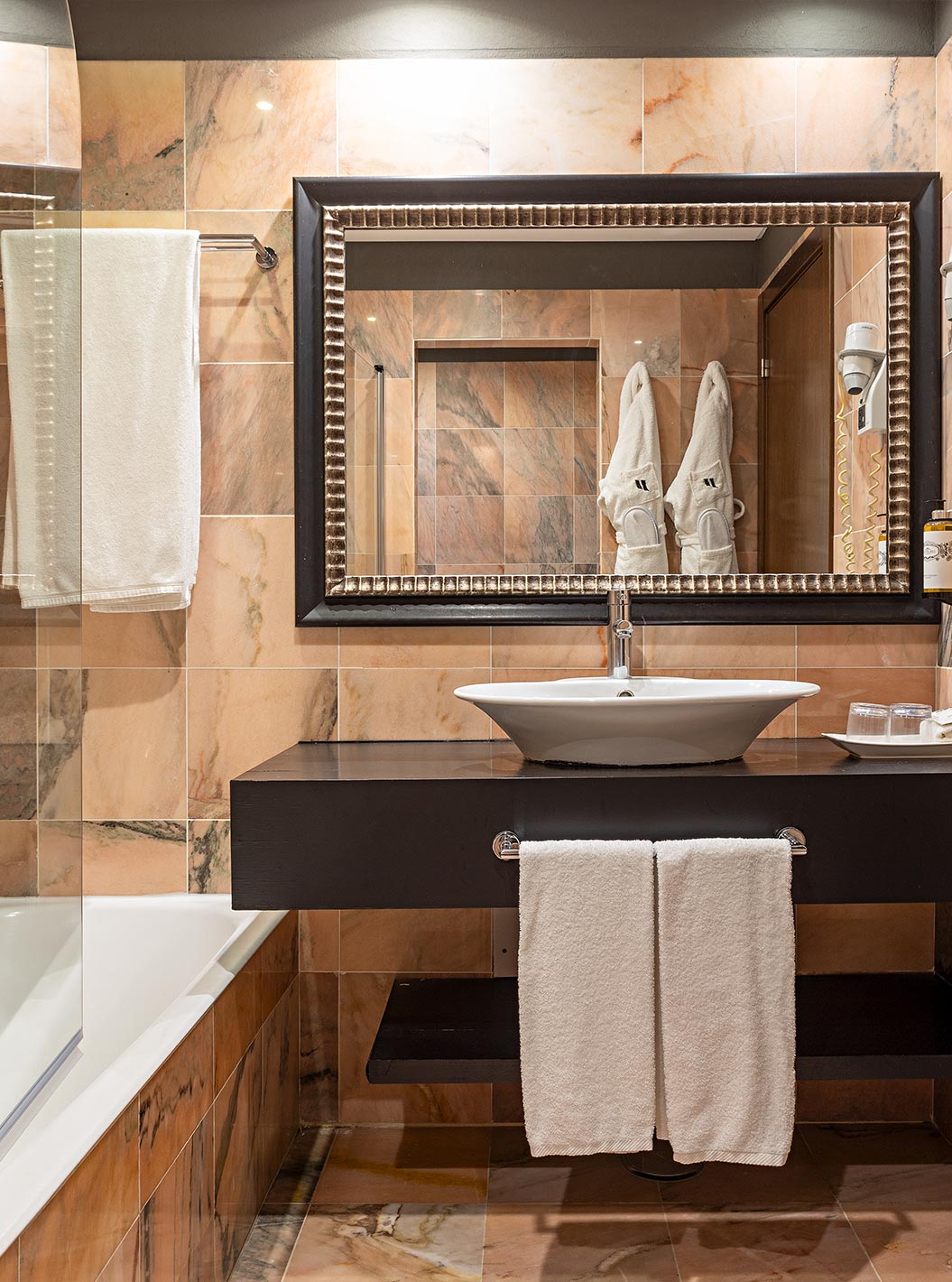 De Cliff Suite T1 bij Pestana Alvor Praia heeft een badkamer met een bad, twee badjassen en een föhn